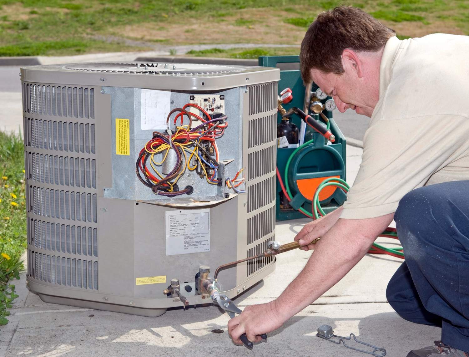 Technician repairing AC unit with tools, offering free estimate AC repair Katy TX services.