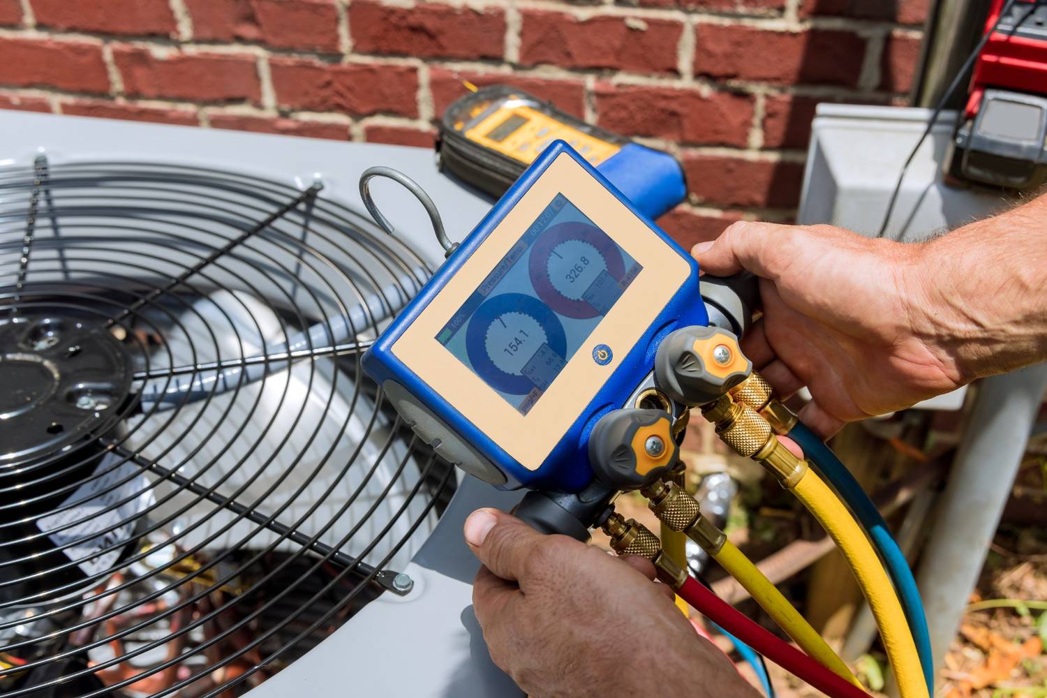 Technician using gauge to service AC unit, showcasing best AC repair company in Katy TX.
