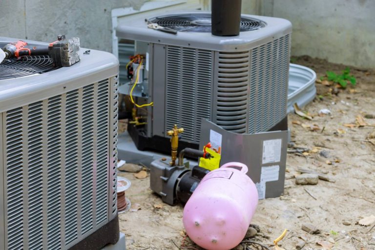 AC units under repair with tools and refrigerant tank, offering 24/7 AC repair services in Katy, TX.