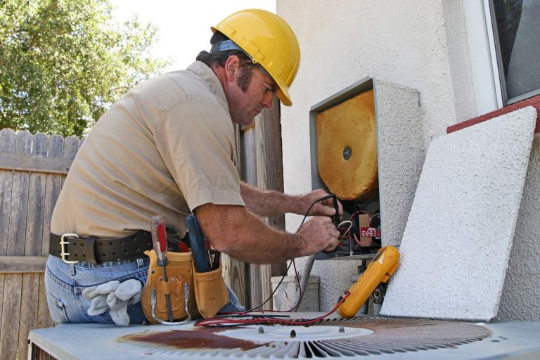 Technician using multimeter on AC electrical panel, offering AC installation in Katy, TX.