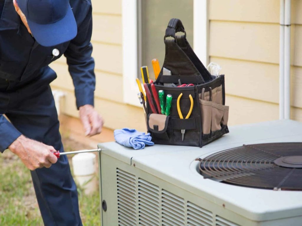 Emergency AC repair near me in Katy, TX: technician repairing air conditioner for quick, same-day home cooling.