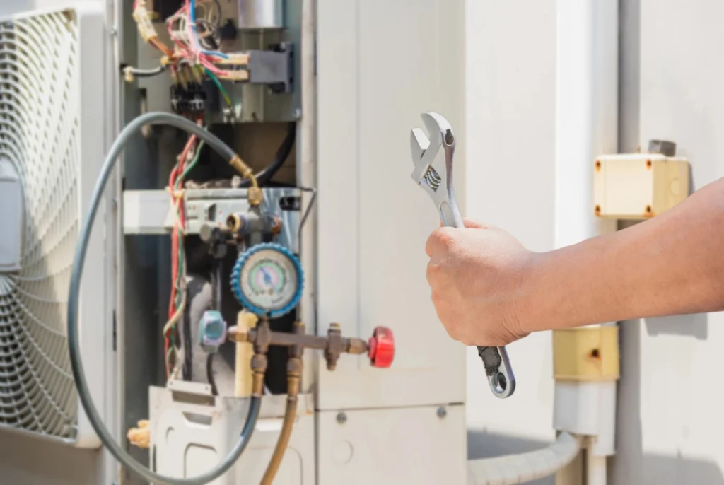 Technician using wrench and gauge for HVAC maintenance by best ac repair company in katy tx ensuring system efficiency