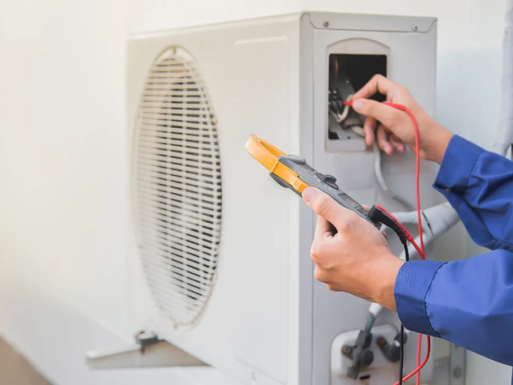 Close-up of technician using multimeter on AC unit for fast air conditioner repair in Katy, TX.