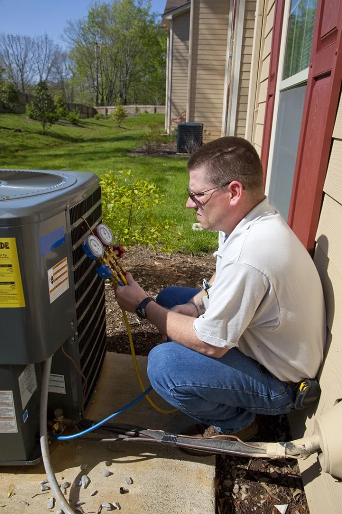 Expert checking AC pressure gauges for energy efficient AC installation services in Katy TX outdoors.