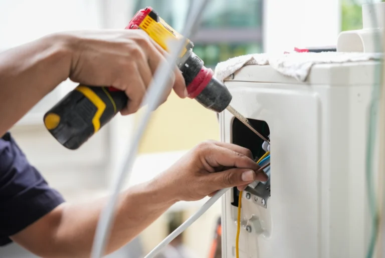 Technician fixing electrical connections on unit with tools for professional cheap ac repair katy tx.