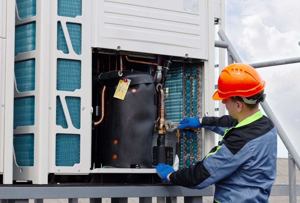 Skilled HVAC technician repairing outdoor AC unit offering flexible financing options in Katy TX