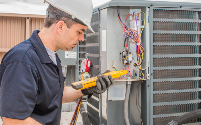 Local HVAC specialist completing an ac installation fulshear tx while testing complex electrical wiring panels.