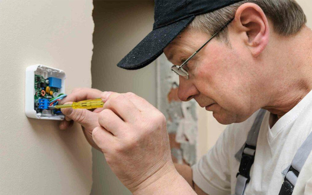 Professional hvac expert finishing a precise ac installation fulshear tx by setting up a new smart thermostat.