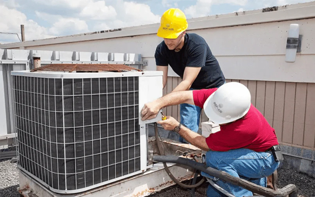 Two skilled experts performing an ac installation fulshear tx by securing a high-efficiency rooftop condenser.