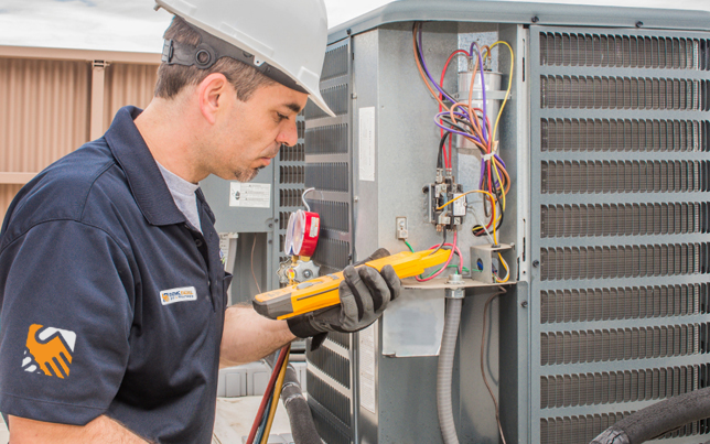 Certified pro completing an ac maintenance fulshear tx by measuring refrigerant levels with professional gauges.