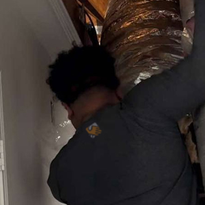 Detailed specialist performing an ac maintenance fulshear tx while inspecting the internal parts of a furnace.