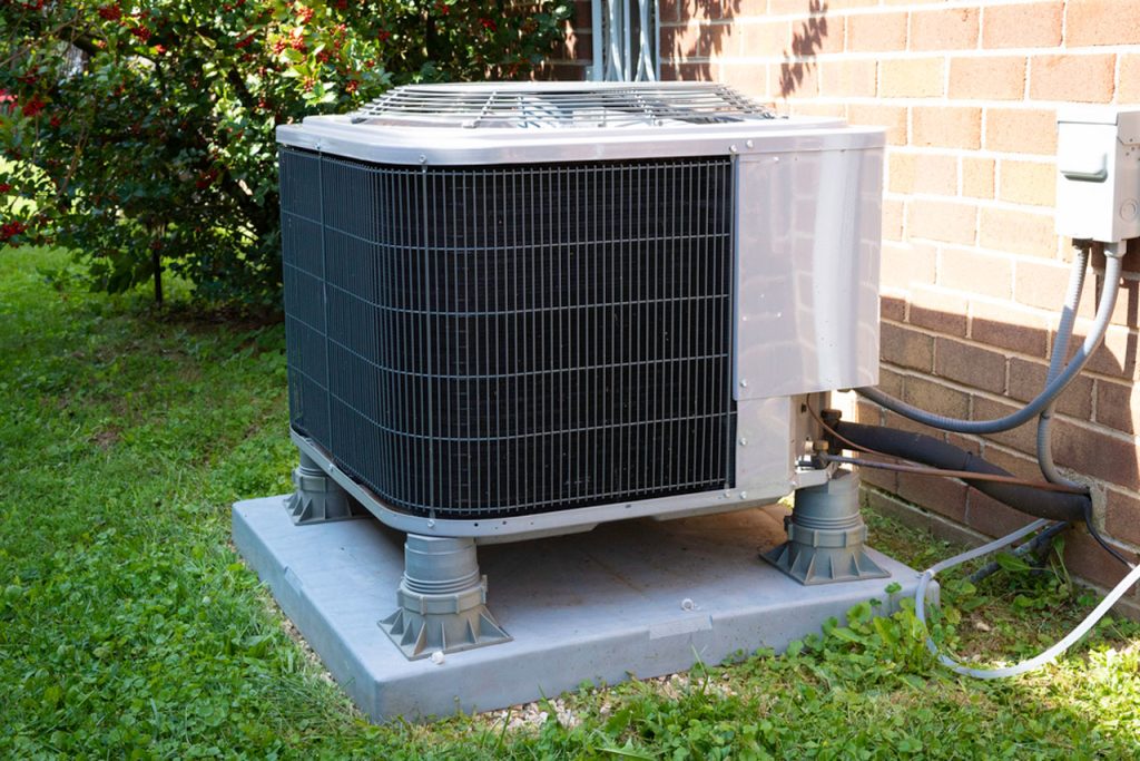 A clean central air condenser unit in a suburban setting, a prime example for professional AC maintenance Katy Tx.