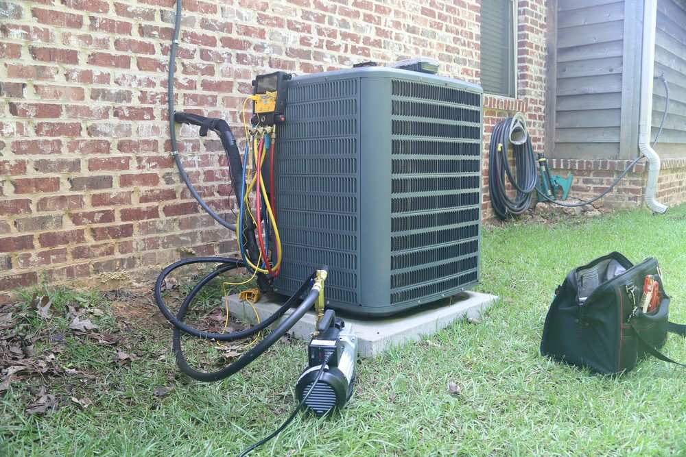 HVAC gauges and a vacuum pump connected to a home AC unit. Expert AC repair Cinco Ranch.
